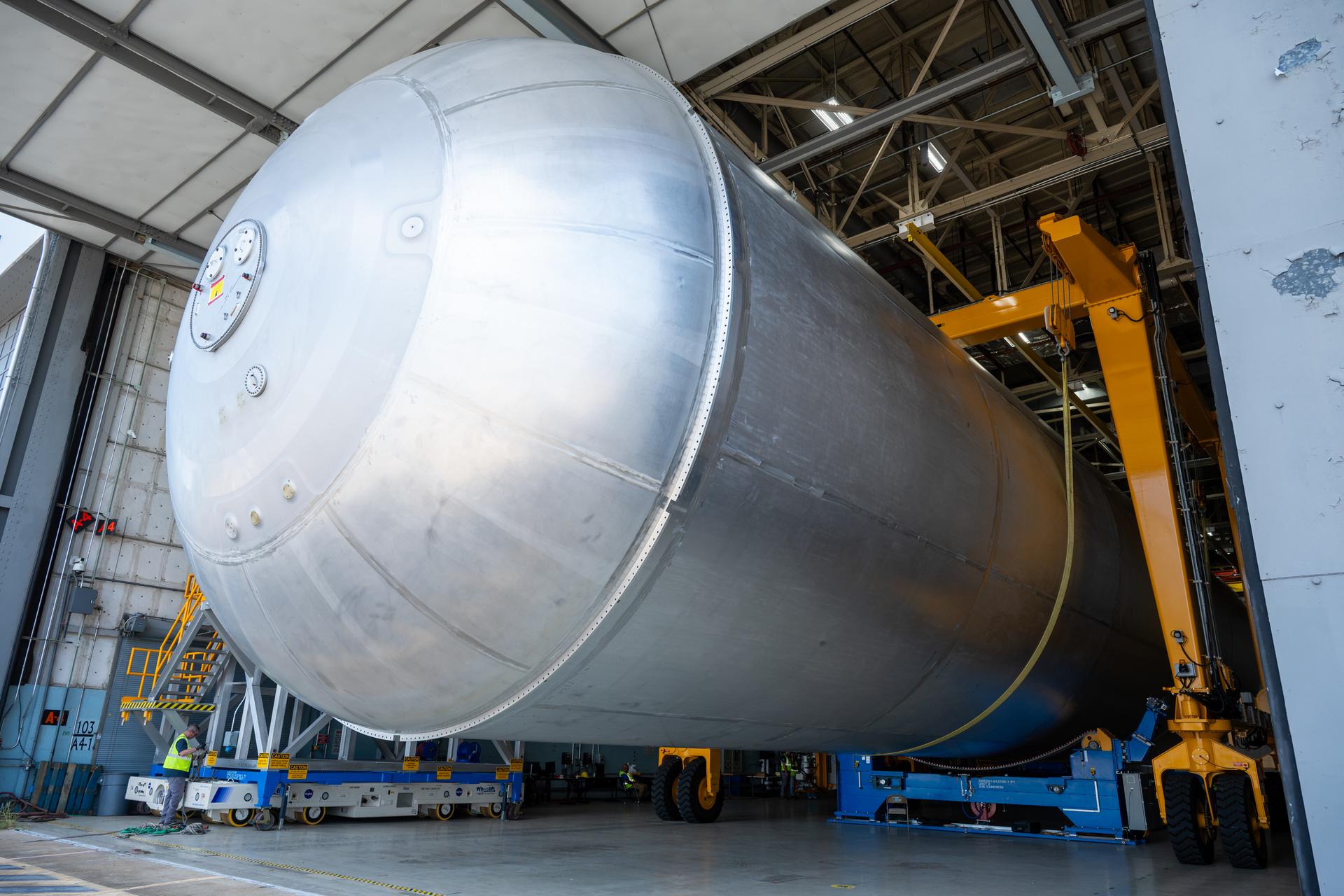 Crews at NASA’s Michoud Assembly Facility in New Orleans transport the 130-foot-tall liquid hydrogen tank from the proof testing building to the main factory on July 15. The liquid hydrogen tank will form part of the core stage for the SLS (Space Launch System) rocket for the agency’s Artemis IV mission, providing thousands of gallons of super-cold propellant to the rocket engines during launch. Soon, teams with SLS prime contractor, Boeing, will move the tank into the facility’s vertical assembly building for cleaning operations.   The liquid hydrogen propellant tank is one of five major elements that make up the 212-foot-tall SLS rocket stage. The core stage, along with its four RS-25 engines at its base, produce more than two million pounds of thrust to help launch NASA’s Orion spacecraft, astronauts, and supplies beyond Earth’s orbit and to the lunar surface for Artemis.      
